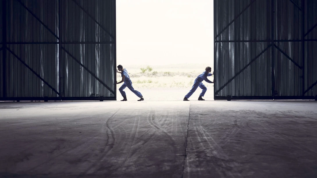 Two men opening warehouse doors
